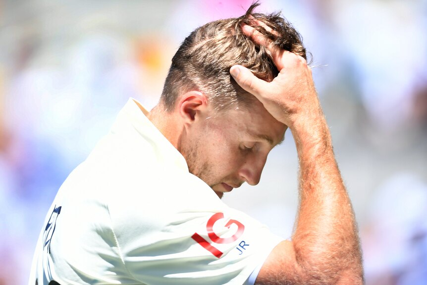 An English batter holds his head as he leaves the field in the first men's Ashes Test at the Gabba.