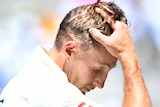 An English batter holds his head as he leaves the field in the first men's Ashes Test at the Gabba.