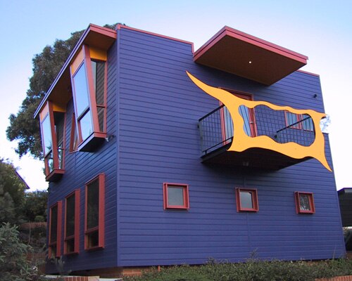 Фиолетовый дом с желтым художественным побегом с балкона и окна, которые продвигаются