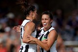 Sharni Layton and Chloe Molloy celebrate a Collingwood goal in the AFLW.