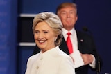 Hillary Clinton with Donald Trump in the background.