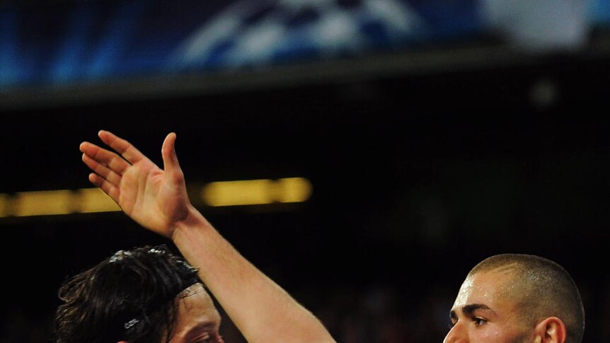 Mesut Ozil congratulates Karim Benzema on his goal at the Bernabeu.