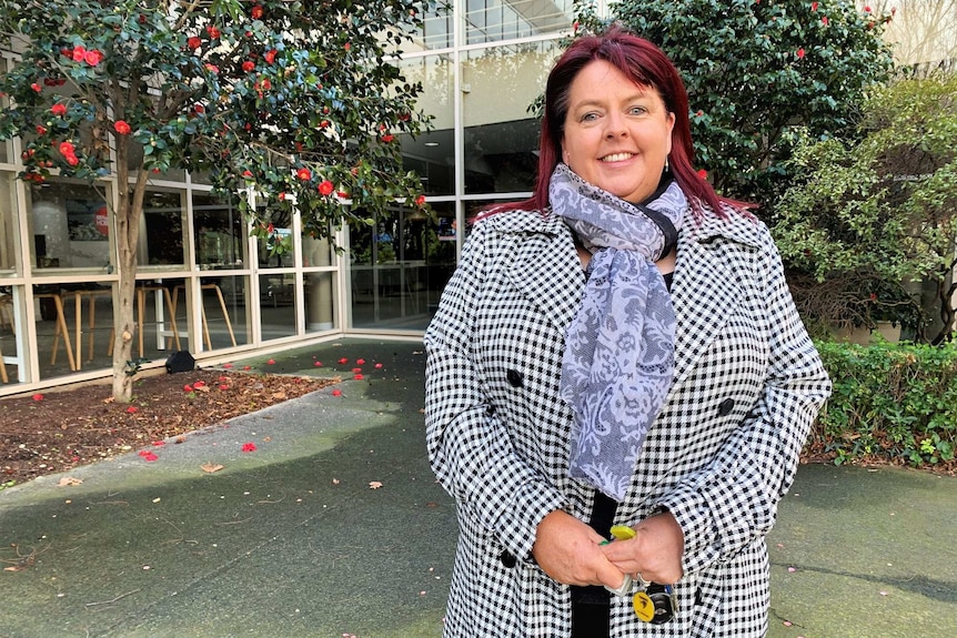 President of the Real Estate of Institute of Tasmania Mandy Welling stands in a courtyard.