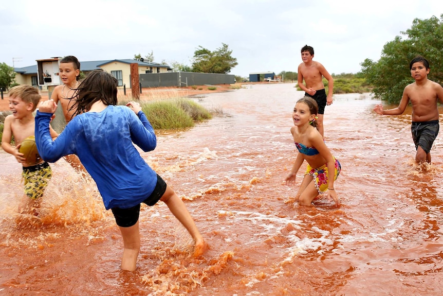 A group of children playing in floodwaters.