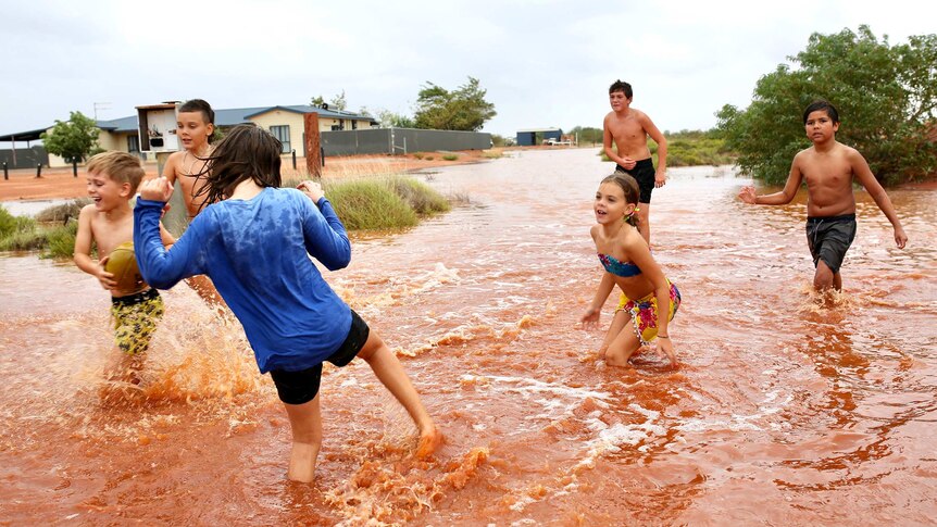 A group of children playing in floodwaters.