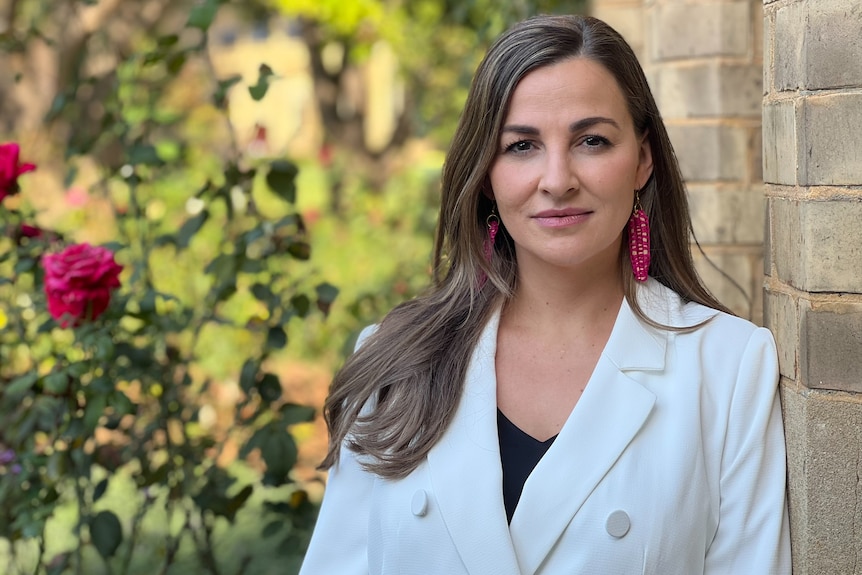 Woman in white suit staring at camera