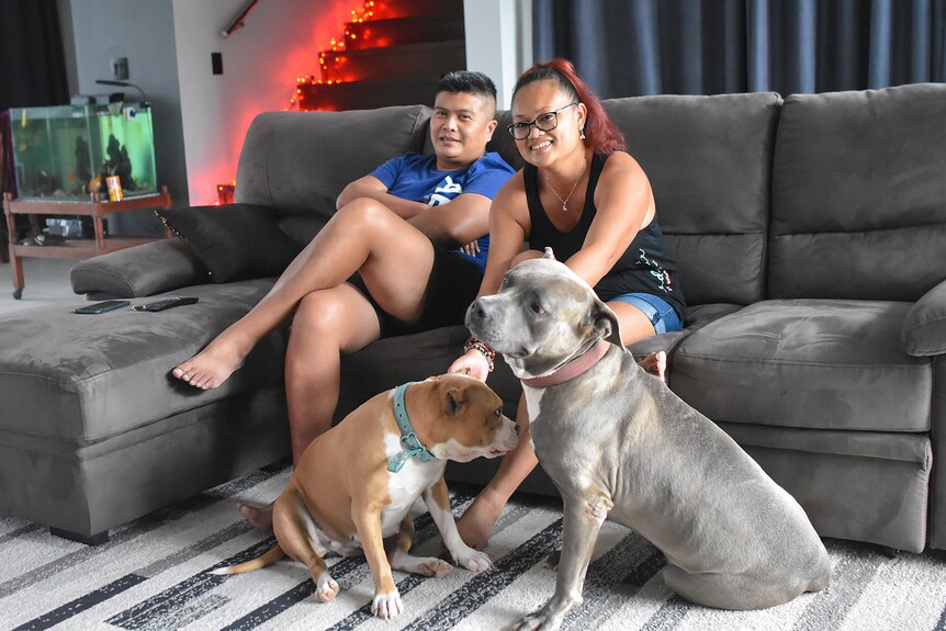 Marvin Dipoikromo and his wife Jenilee Dipoikromo - Kartowidjojo sit in their living room with their dogs Luna and Ace.
