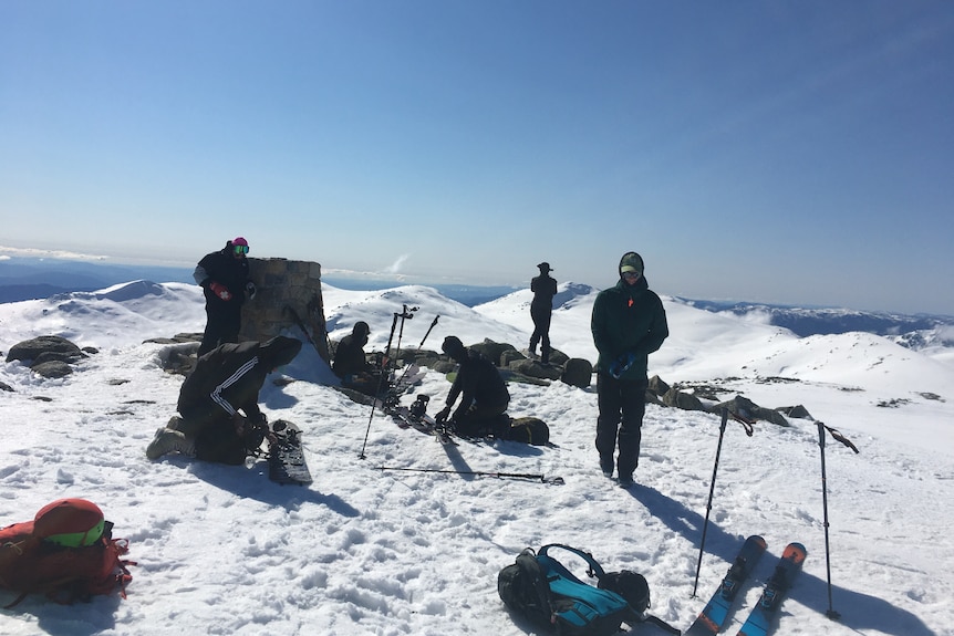 A group of people on top of a snowy mountain.