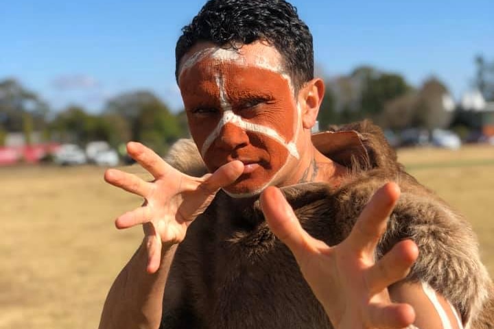 Seorang pria Aborigin dalam pakaian tradisional. 