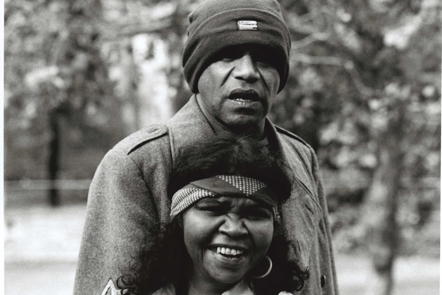 A black and white photo of Archie Roach and Ruby Hunter smiling together.