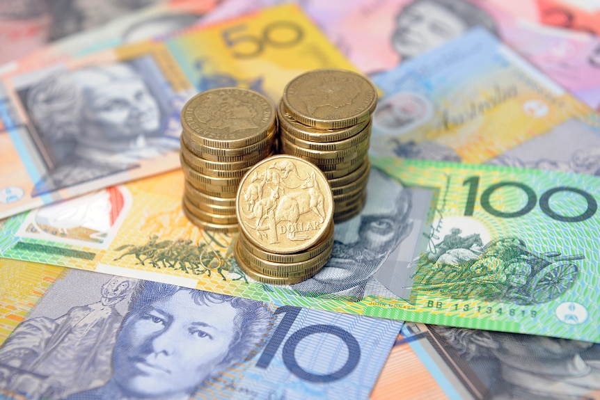 Picture of Australian one dollar coins stacked on top of note currency