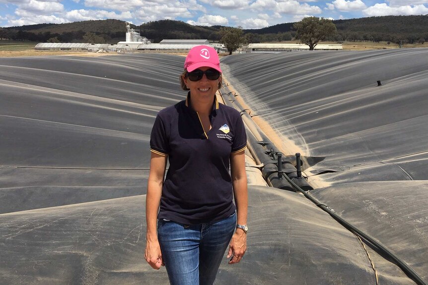 Piggery owner Edwina Beveridge standing in front of a giant pit of pig manure which gets turned into methane gas,