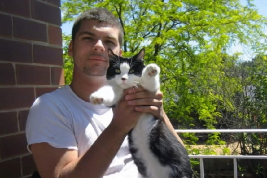 Young man holding a cat