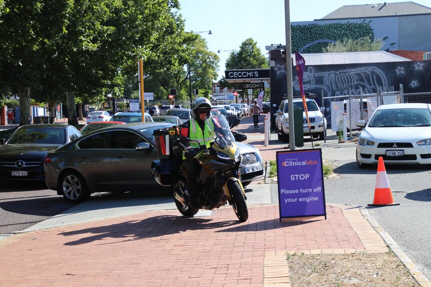 Cars queue at a drive-through COVID testing clinic in Perth.