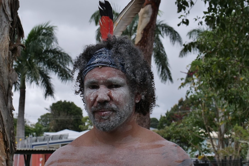 A Gumbaynggir man wearing traditional clothing and face paint.