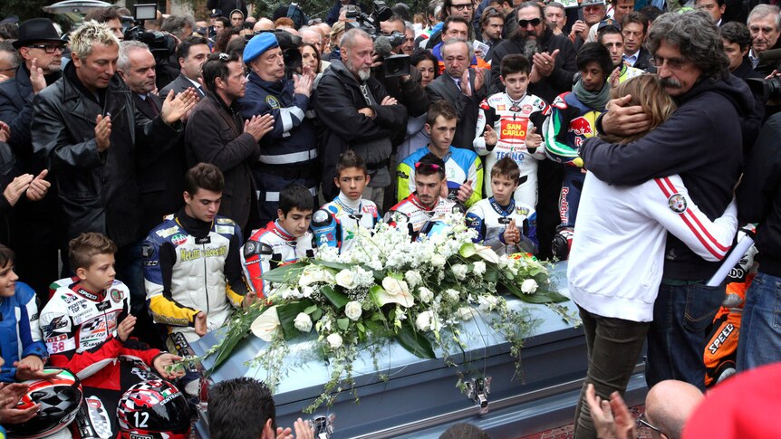 People surround the coffin of Marco Simoncelli during his funeral in Italy