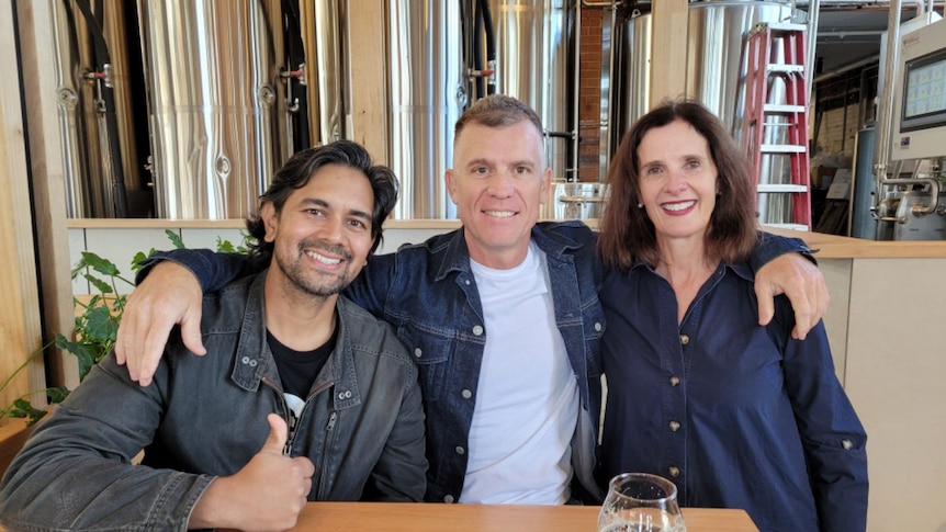 Two men and a woman seated in a bar