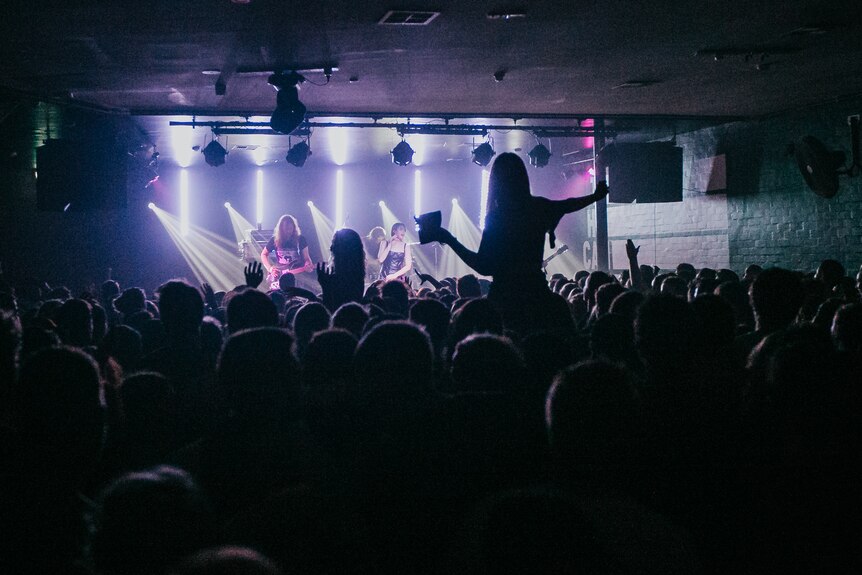 A crowd in silhouette enjoys the lights and music of a Preatures show at Newcastle's Cambridge Hotel
