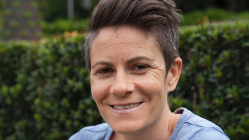 Woman sits in South Bank parklands in Brisbane.