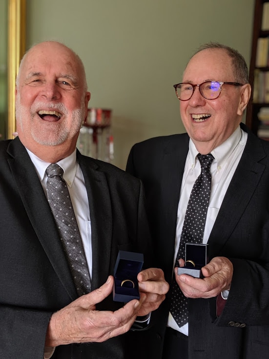 Father John Davis and Father Rob Whalley show off their wedding rings