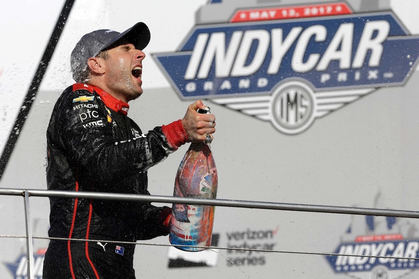 Will Power is sprayed with champagne after winning the IndyCar Grand Prix in Indianapolis.