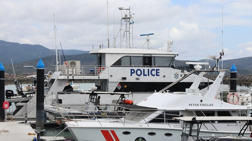 A large police boat moored in a marina.