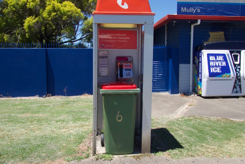 A bin in a Telstra phone box