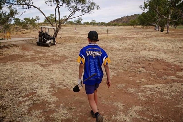 boy walking on dry field