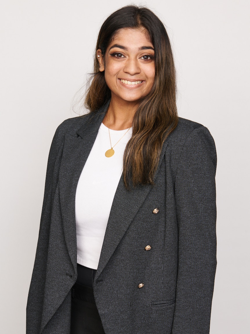 A woman smiling in a suit. 