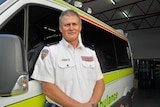 Tasmanian paramedic Steve Hickie stands in front of an ambulance.