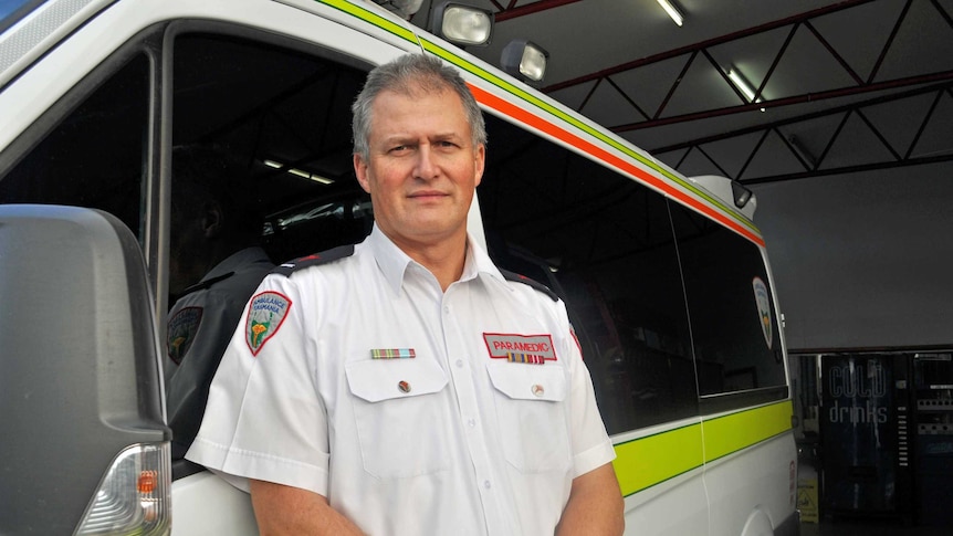 Tasmanian paramedic Steve Hickie stands in front of an ambulance.
