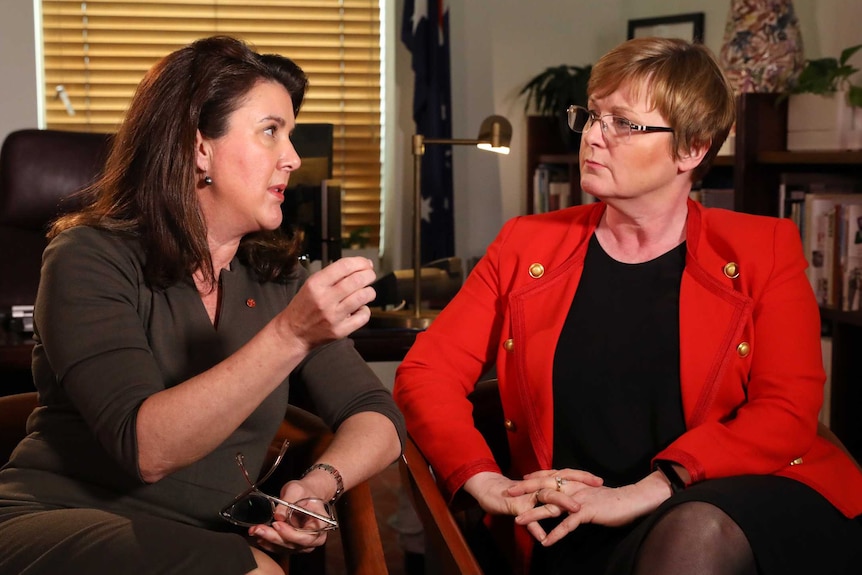 Jane Hume and Linda Reynolds sit in chairs next to each other, in an animated conversation.