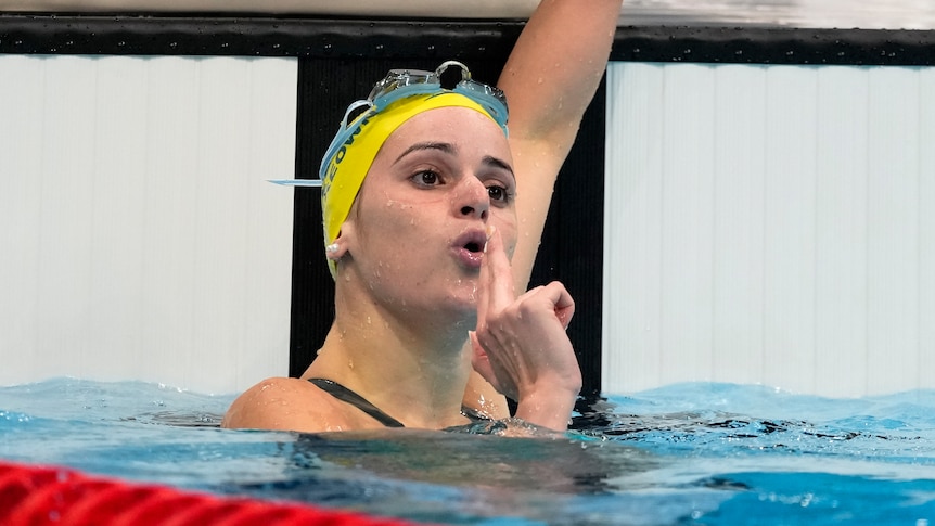 Swimming blowing a gun gesture after winning an Olympic medal 