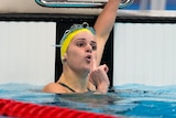 Swimming blowing a gun gesture after winning an Olympic medal 