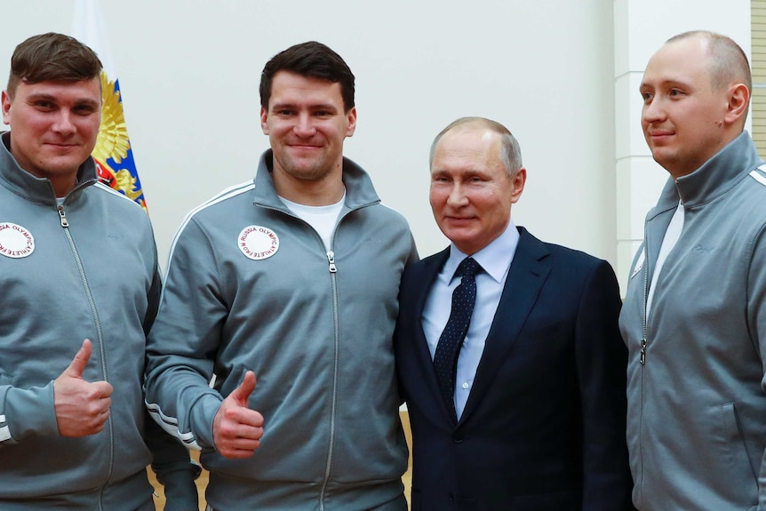 Vladimir Putin poses for a photo with Russian athletes who will take part in the upcoming 2018 Pyeongchang Winter Olympic Games.