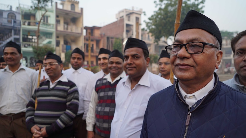 A group of men stand facing the camera.