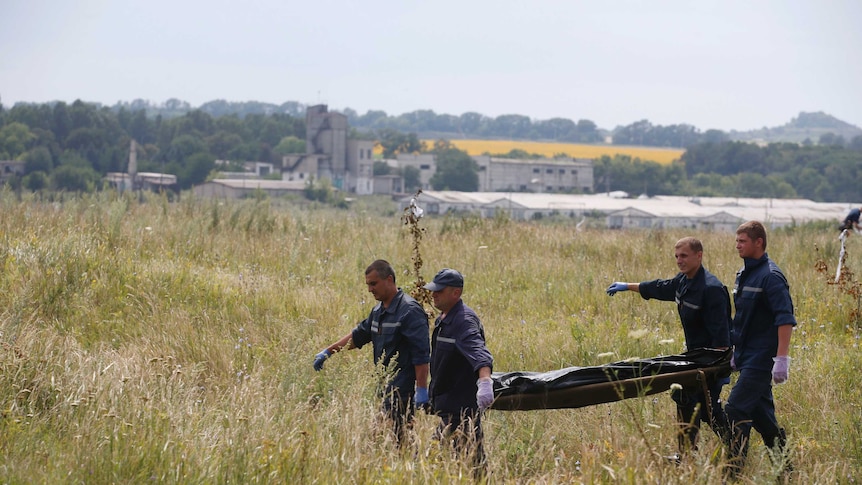 Members of the Ukrainian Emergency Ministry carry a body at the crash site of Malaysia Airlines Flight MH17