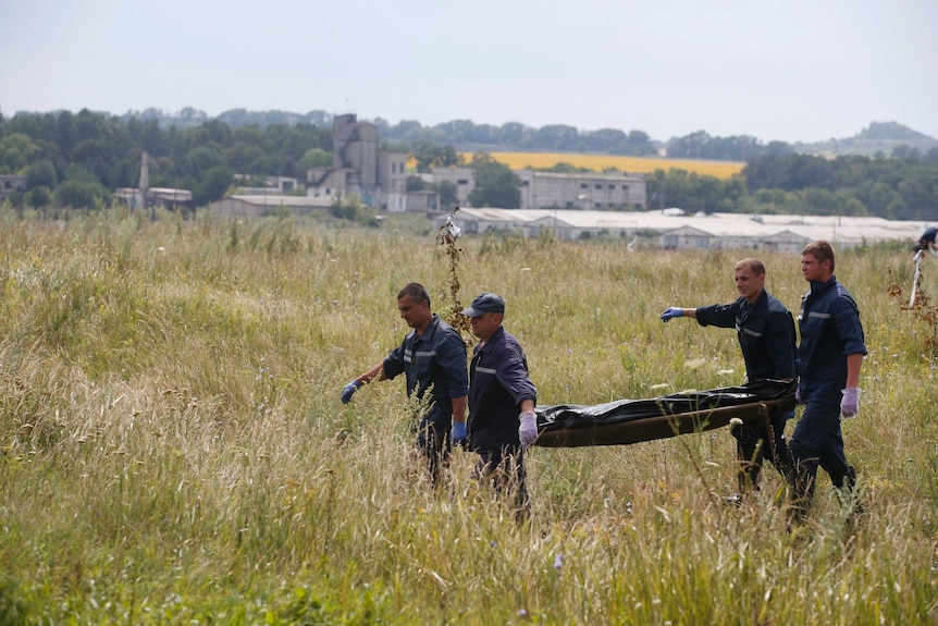 Members of the Ukrainian Emergency Ministry carry a body at the crash site of Malaysia Airlines Flight MH17