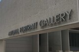 A metal sign reading 'NATIONAL PORTRAIT GALLERY' on the front of a cement building.