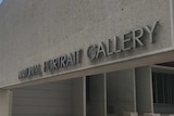 A metal sign reading 'NATIONAL PORTRAIT GALLERY' on the front of a cement building.