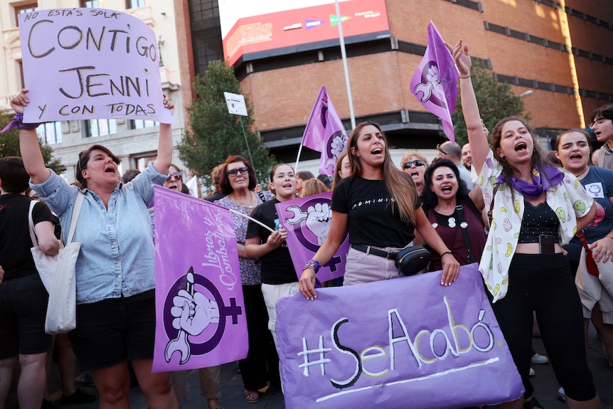 A large group of women shouting and holding signs 