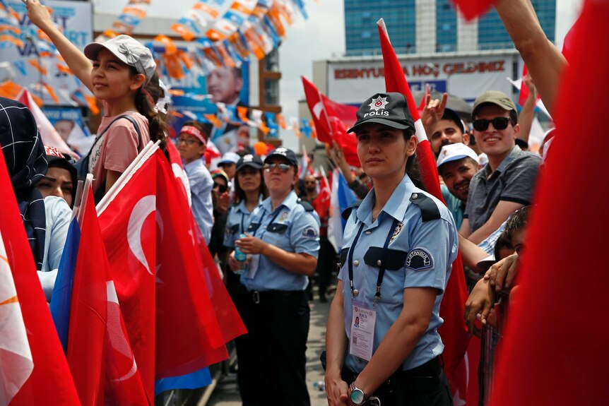 Police officers stand among supporters of Turkey's President