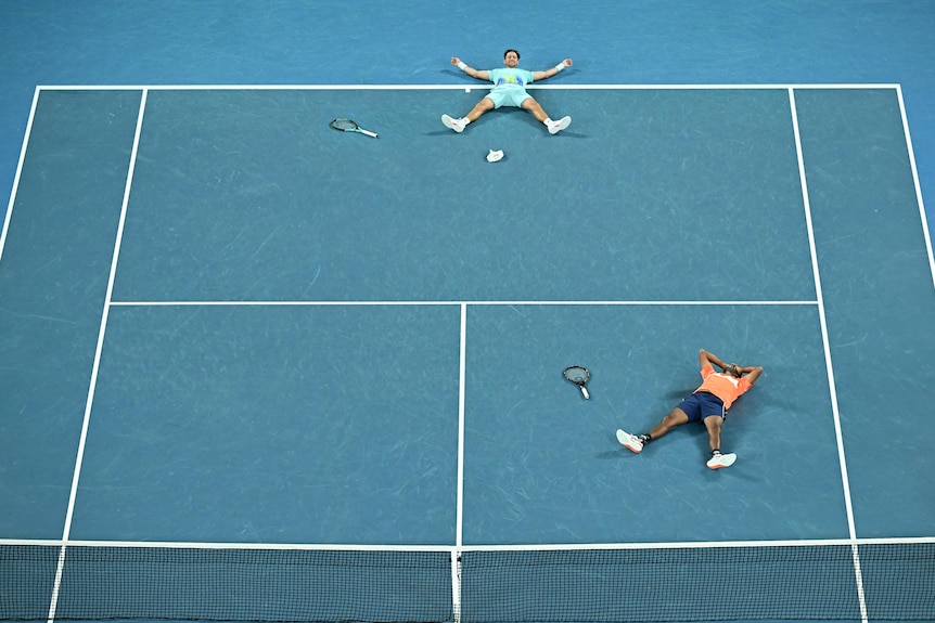Two tennis players lie on back on Aus Open court 