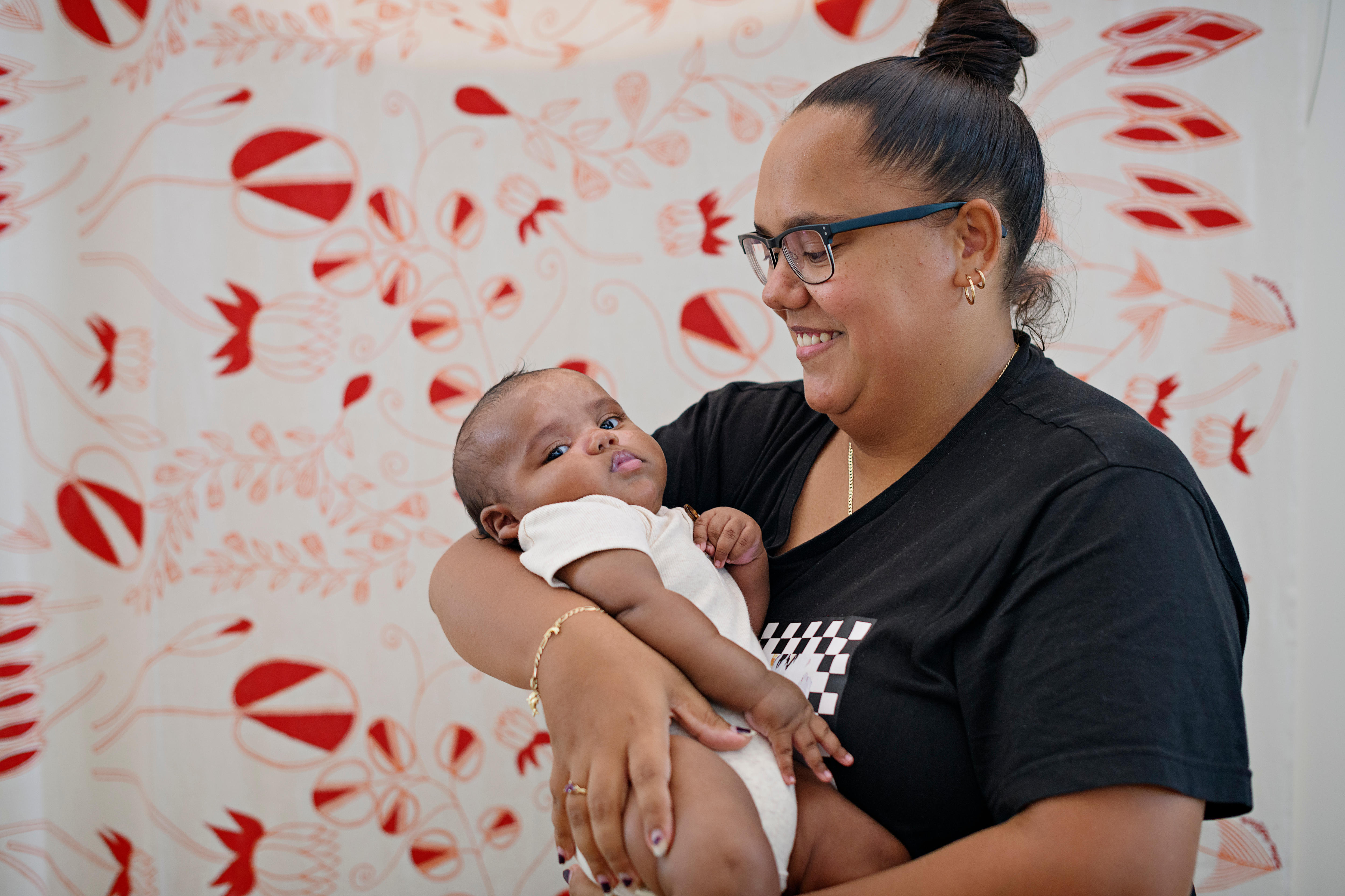 An Aboriginal woman smiles at her baby