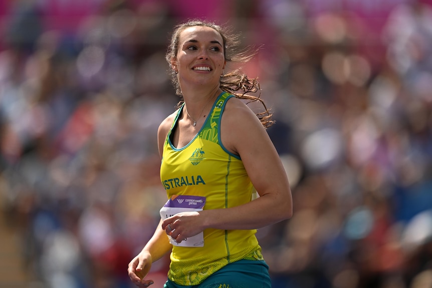 Mackenzie Little sonríe ampliamente con su camiseta del equipo de Australia