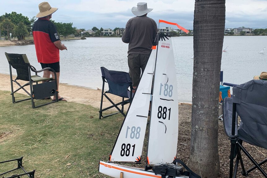 Two members of paradise Radio Yacht Club with remotes watching on during a race at Emerald Lakes.