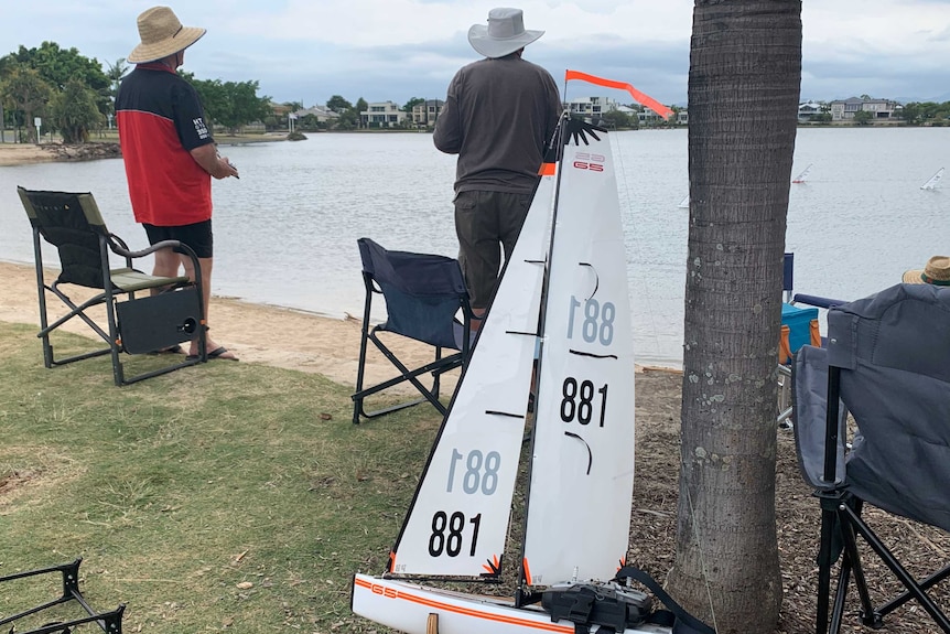 Two members of paradise Radio Yacht Club with remotes watching on during a race at Emerald Lakes.