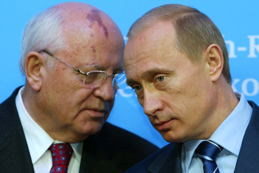 Russian President Vladimir Putin leans in to listen to Mr Gorbachev 