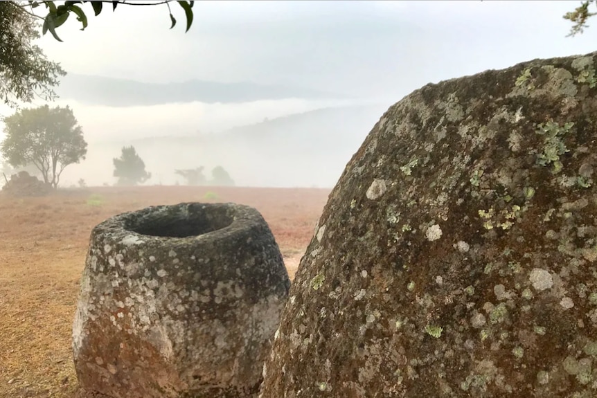 A large stone jar on a hillside