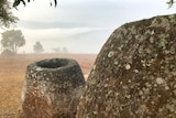 A large stone jar on a hillside